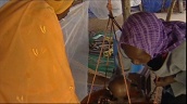 Women weighing baby in makeshift medical hut&sbquo;  Darfur