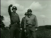 General George S Patton looks through binoculars and points directions as he organises movements on battlefield during World War II; 1940\%27s