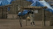 Small Sudanese child stands underneath wooden shelter to escape rain&sbquo;  Darfur; Nov 05