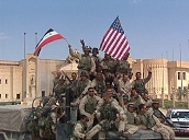 Soldiers pose on top of army truck waving Iraqi and US flags in front of bomb damaged palace&sbquo;  Tikrit; 14 Apr 2003