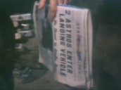 Tilt up from American soldier holding newspaper following successful Apollo 11 moon landing mission&sbquo;  Vietnam; July 1969