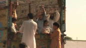 Group of Swat Valley refugees wave to camera from truck as they leave encampment following violence between Taliban and government forces&sbquo;  Pakistan; 3 August 2009