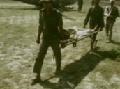 Injured refugees are carried by troops to helicopter&sbquo;  Vietnam; 1975