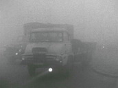 Traffic driving through thick smog&sbquo;  prior to Clean Air Act&sbquo; UK; 1955