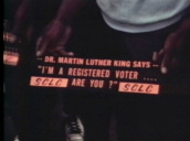 African-American man holding Civil Rights movement sign from Southern Christian Leadership Conference saying "Dr Martin Luther King says.. I\%27m a registered voter.... Are you?"; 1960s