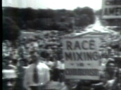Pan right over crowd protesting at racial desegregation in schools&sbquo;  one person carrying sign saying "Race mixing is communism"&sbquo; Little Rock; 23 Sep 57