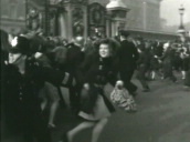 Police struggle to hold back screaming Beatles fans as car arrives at Buckingham Palace&sbquo;  fans run after car and policemen loose helmets; 27 Oct 65