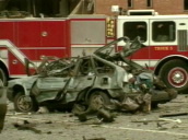 Zoom out from burnt out car and devastation caused by Oklahoma City Bomb; 19 Apr 95