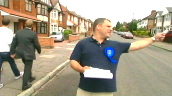 Conservative Party worker in street wearing blue rosette&sbquo;  holding clipboard and organising leaflet drop for Leicester by election; 09 Jul 04