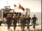 Company of marines marching off landing craft and up beach are welcomed by Vietnamese women&sbquo;  Vietnam; 1966