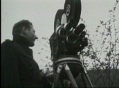 Amateur film of actor Danny Kaye standing behind film camera chatting to cameraman Ken Gordon at opening of Festival of Britain&sbquo;  London; 1951