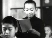 History text books and primary school lesson&sbquo;  one boy stands and reads aloud to class&sbquo; Japan; 1946
