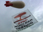 Greenpeace banner protesting against nuclear testing hangs from barrage balloon&sbquo;  Paris; 1995