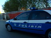 Blue and white police car with flashing light travels along road&sbquo;  Naples