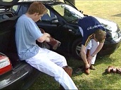 Prince Harry sits in boot of car cleaning polo boots as Prince William puts on boots at polo match&sbquo;  England; 2000\%27s