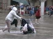 Tourists struggle to walk across flooded piazza in bad weather&sbquo;  Venice; 17 Jul 02