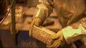 Person in protective silver suit moves blocks of gold at Pascua-Lama gold mine&sbquo;  Chile; 29 Dec 06