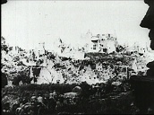 German army marching through bomb-damaged town on Western Front in World War I&sbquo;  Germany; 1910\%27s